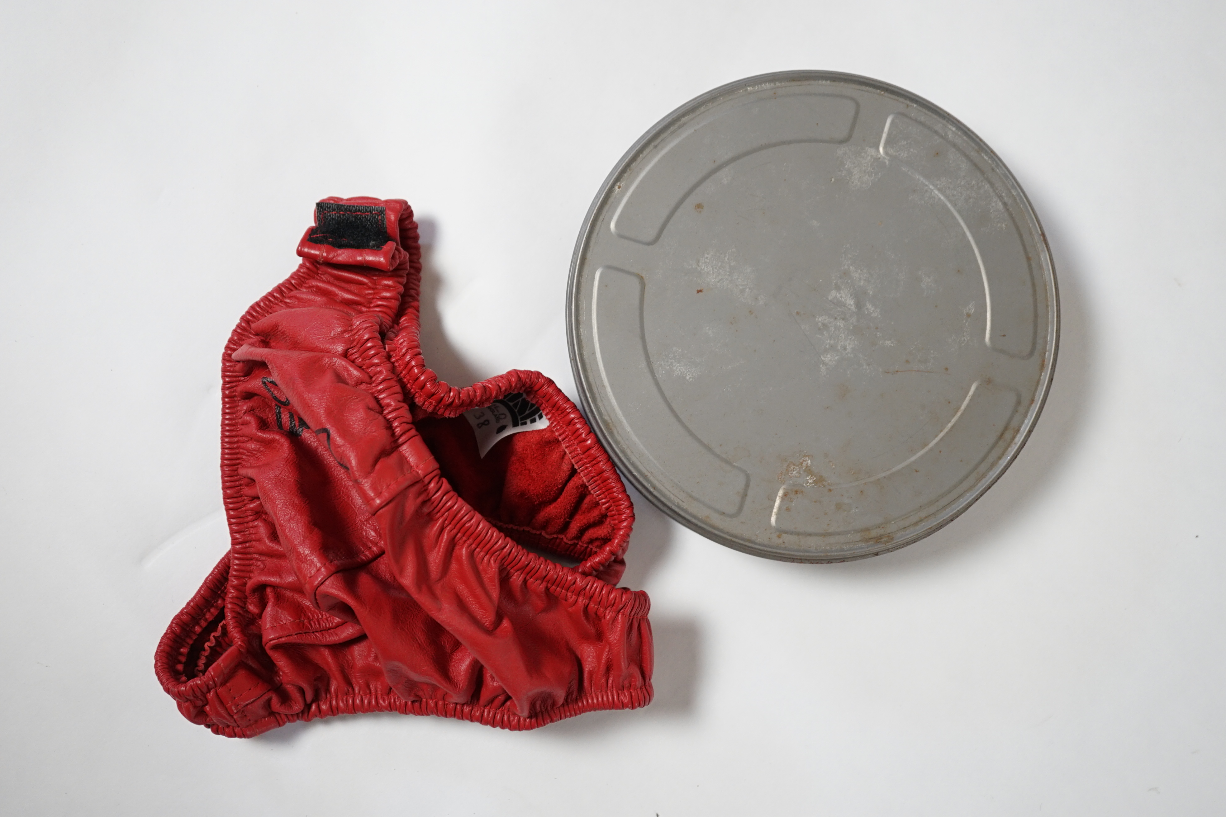 A red leather thong, as worn by Tom Wilkinson in the film The Full Monty and signed by him, together with a signed note confirming authenticity.